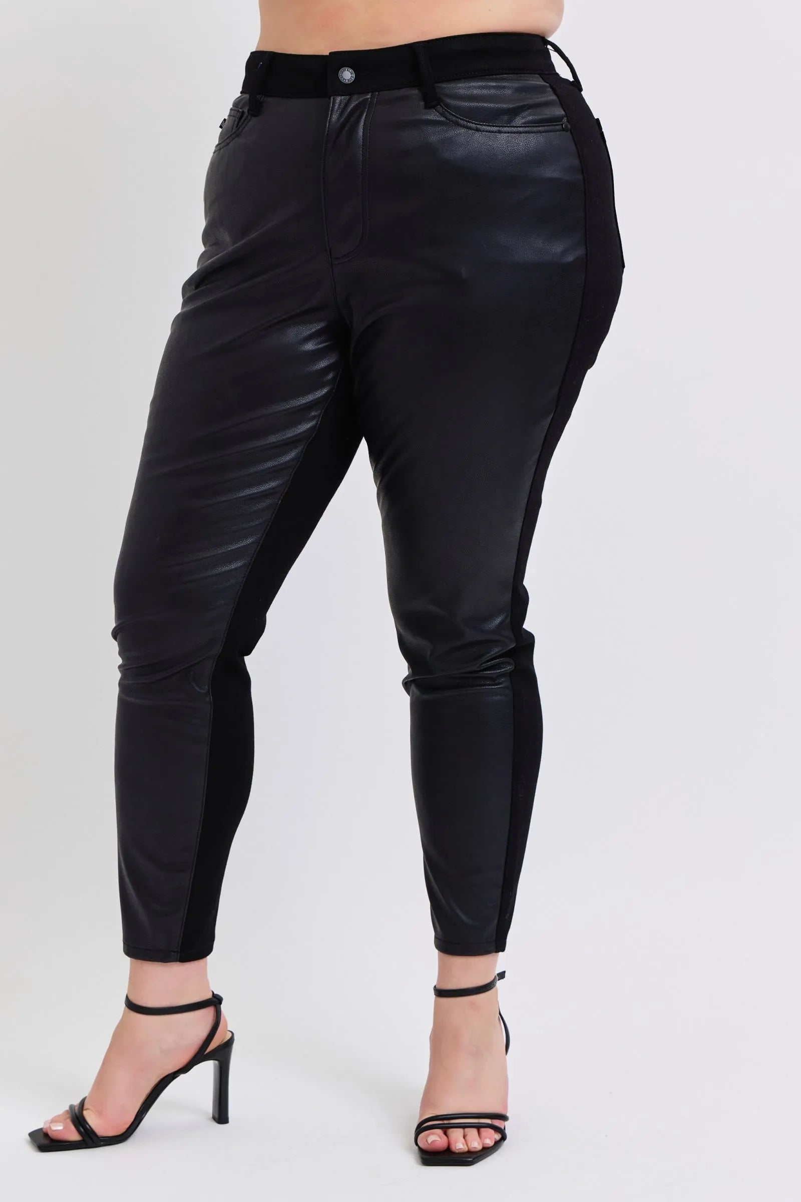 Black faux leather skinny pants, front close-up of waistband, pockets and tapered cuffs
