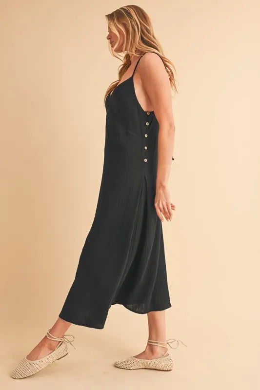 Schwarzes Midi-Cami-Kleid in Seitenansicht, seitliche Knopfleiste und Rocksaum