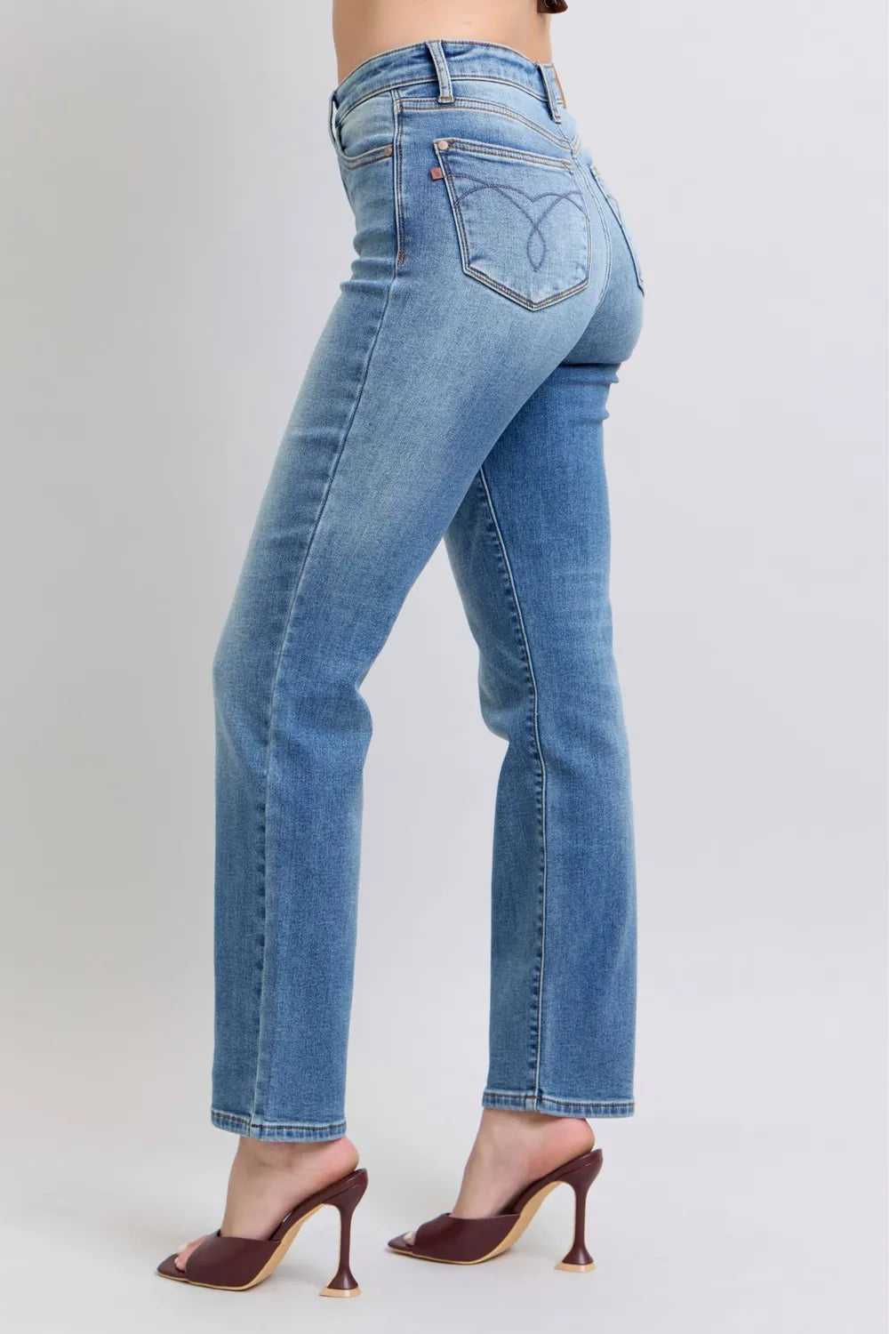 Side view of medium-wash vintage straight jeans with embroidered back pocket stitching