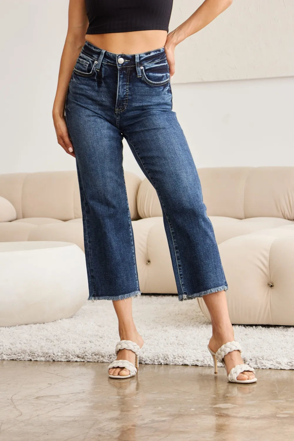 High-waist dark-wash jeans with flared leg and raw cuff hem