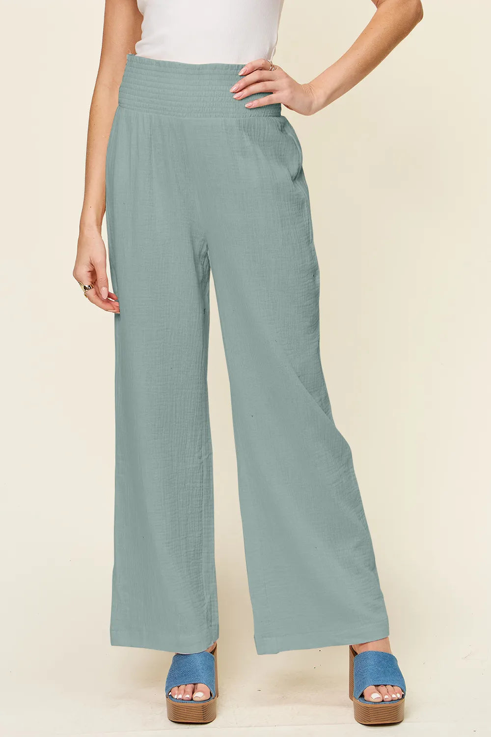 Teal wide-leg pants with smocked waist and textured fabric