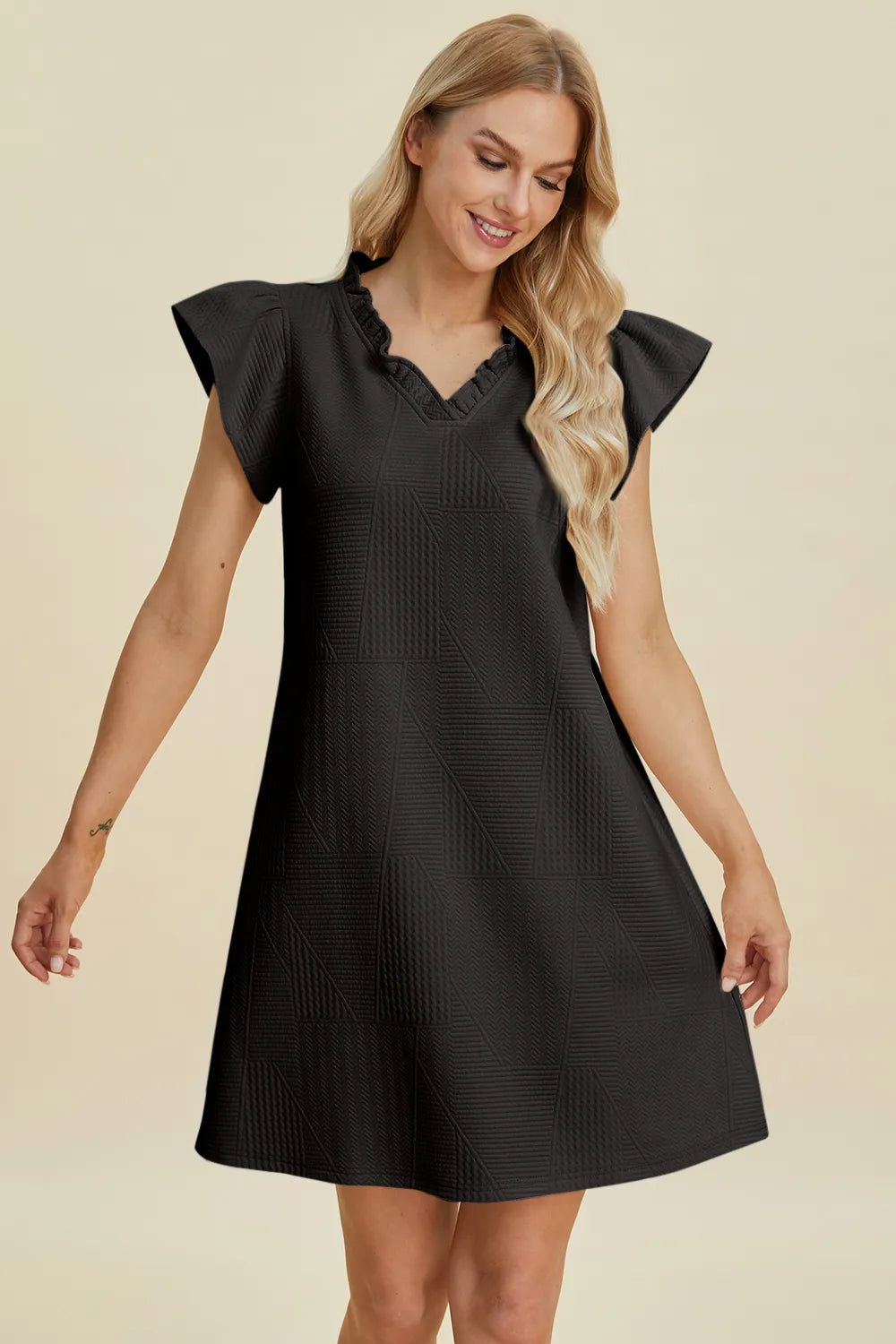 Ruffled V-neck cap sleeve dress in black, three-quarter front view with ruffled shoulders.