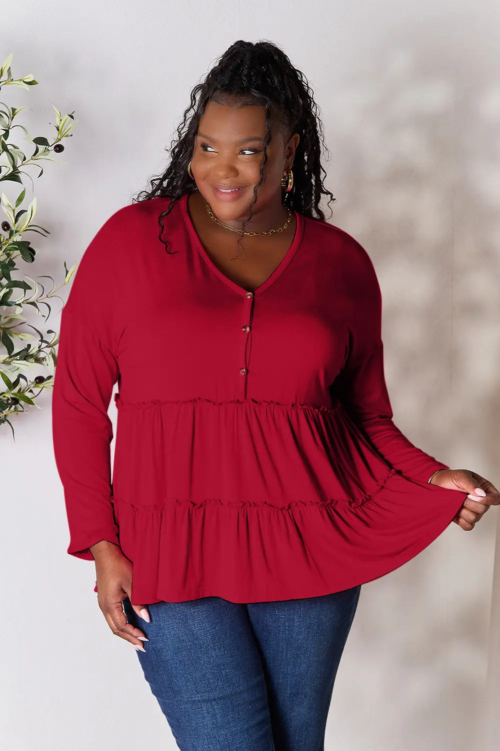 Burgundy V-neck half-button blouse with tiered ruffle hem and three-quarter sleeves