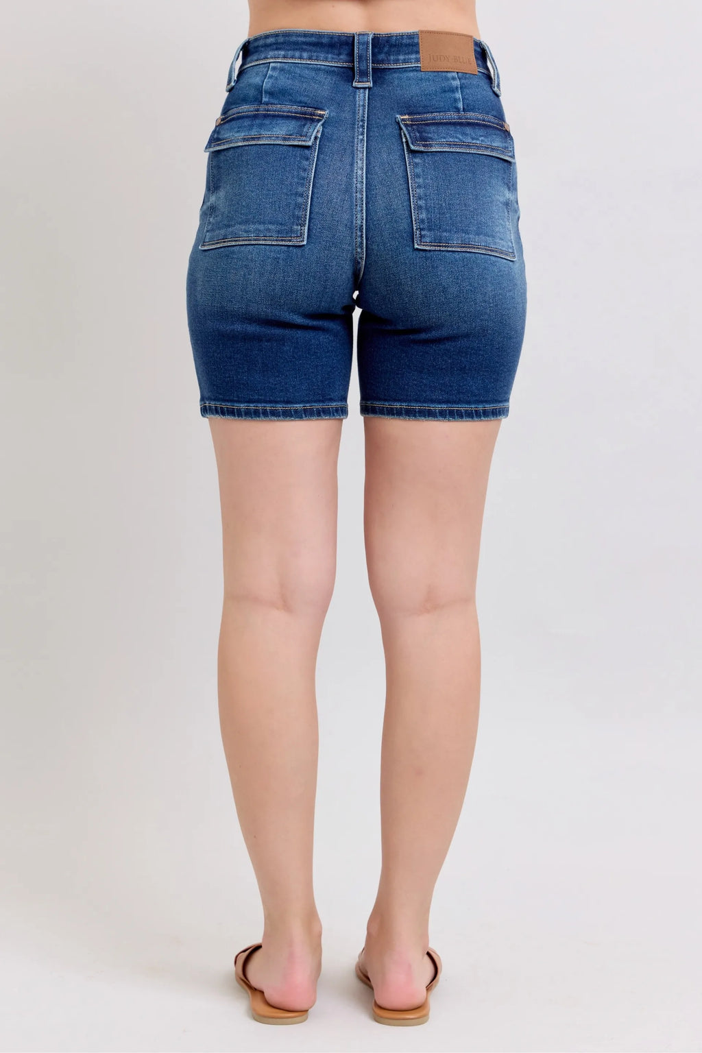 High-waist denim bermuda shorts back view with two flap pockets and center seam