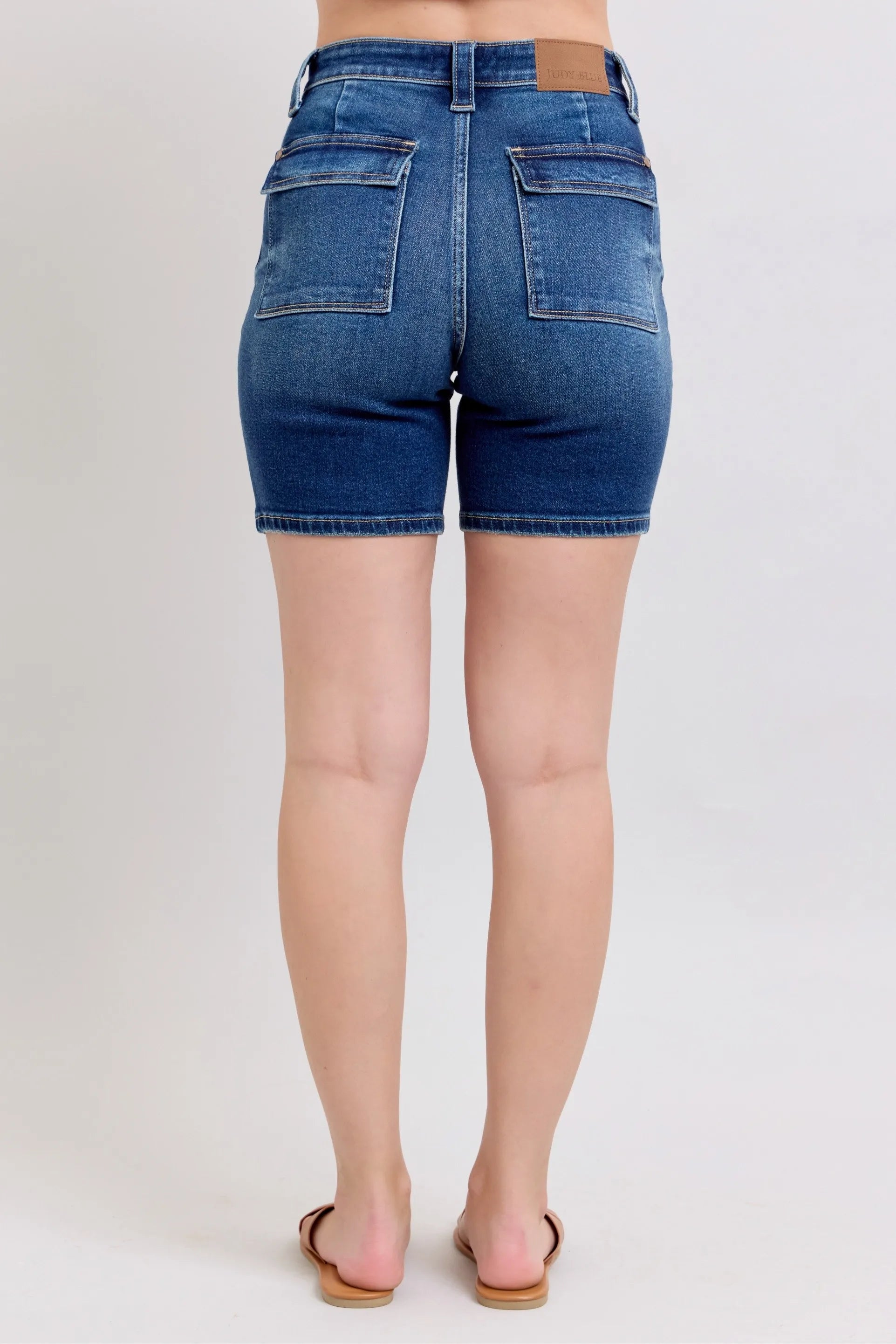 High-waist denim bermuda shorts back view with two flap pockets and center seam