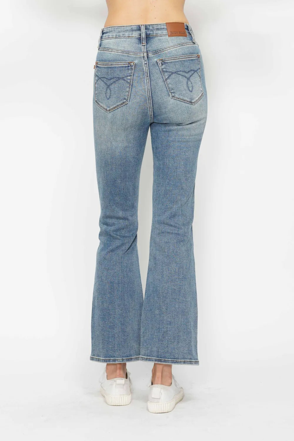 Light blue bootcut jeans, back view; embroidered pockets and rear yoke seam