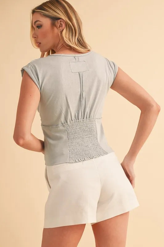 Light blue-gray cap sleeve cropped top, back with central seam and smocked waist