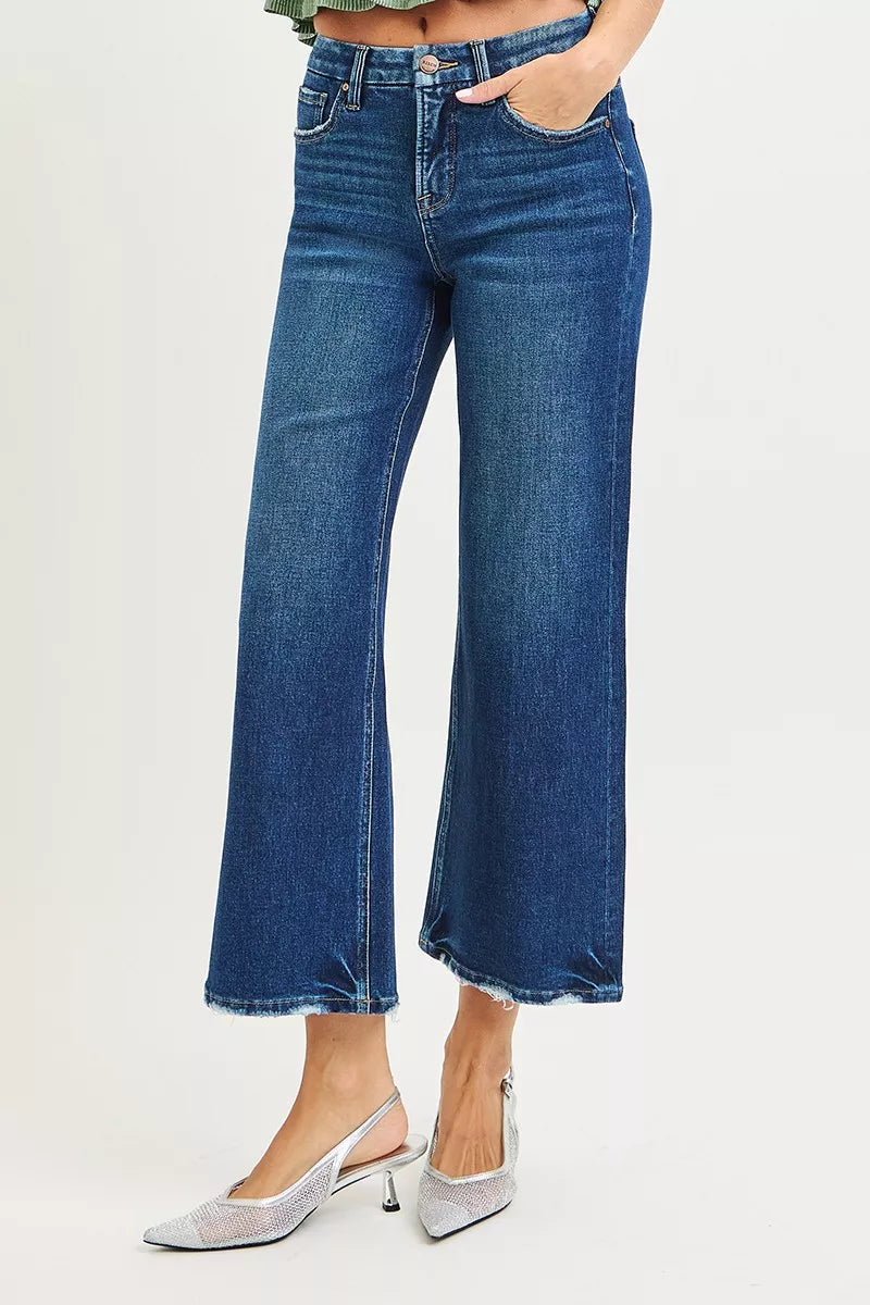 Dark wash high-rise wide-leg crop jeans, side profile with frayed hem