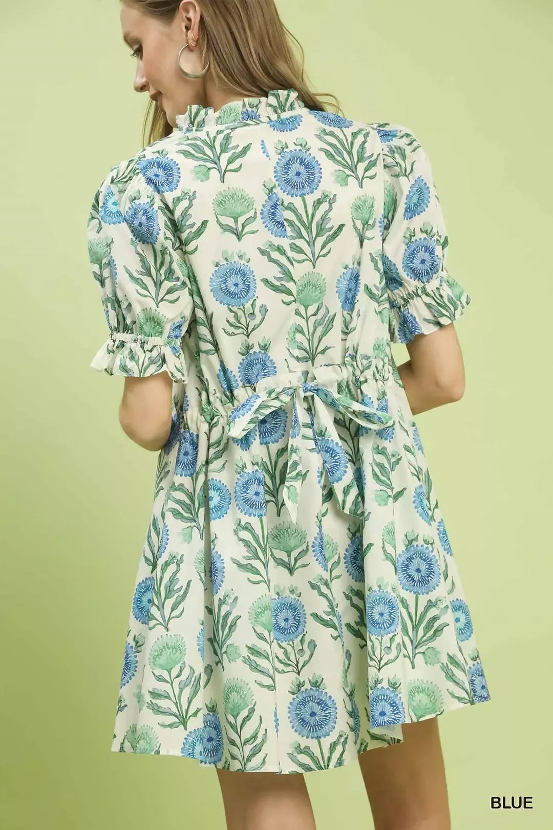 Back view of blue floral babydoll dress with gathered waist tie and puff sleeves