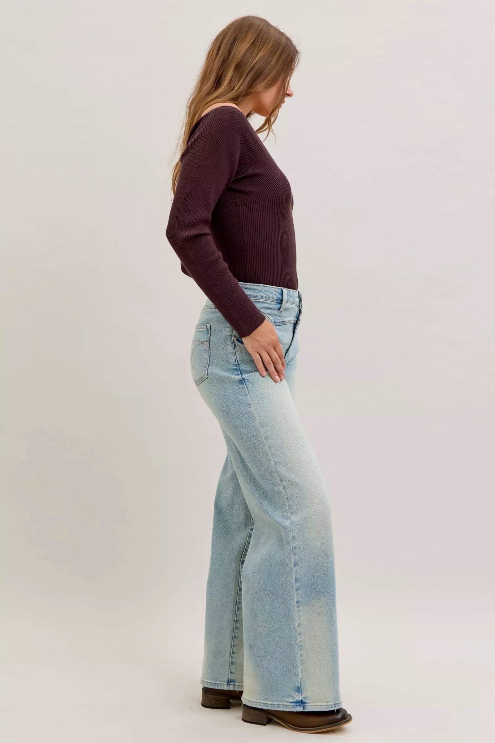 Light blue high-waist straight jeans, side profile with belt loops and whiskered finish