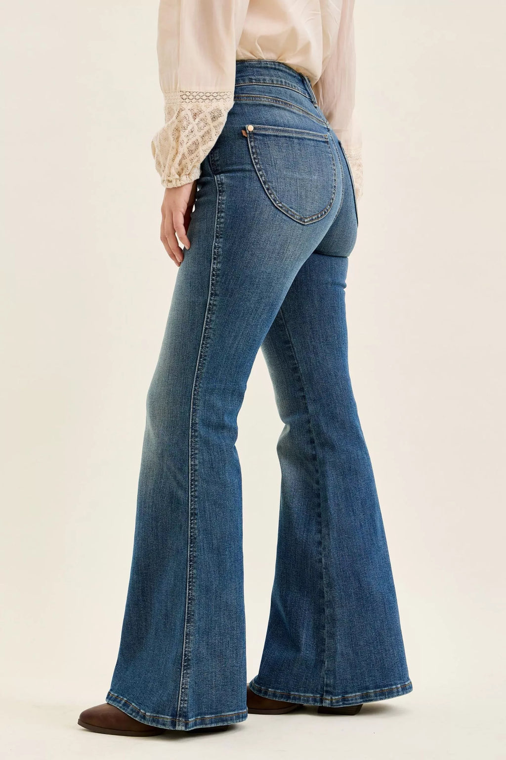 Dark denim high-waist flare jeans, back/side view with stitched back pockets