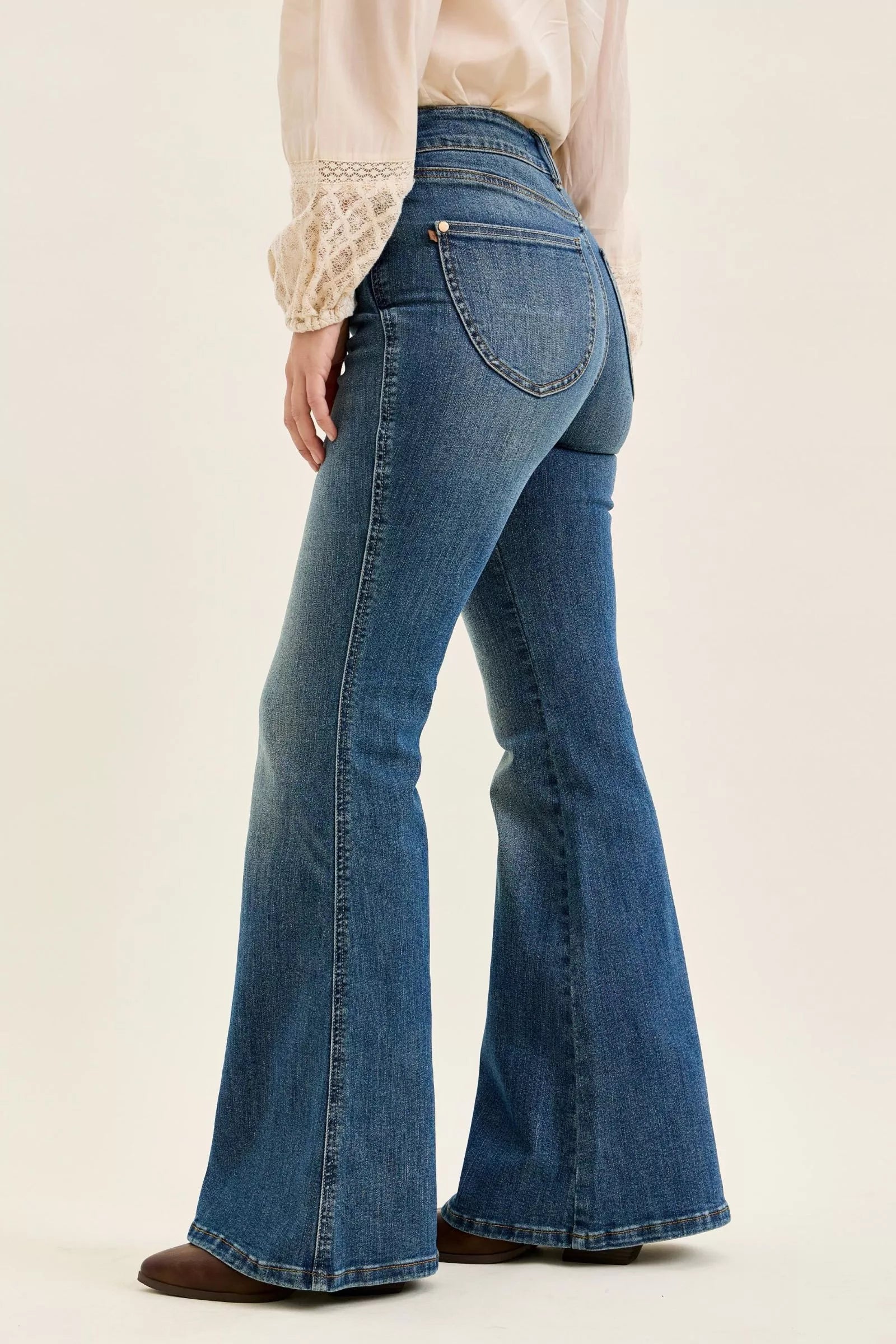 Dark denim high-waist flare jeans, back/side view with stitched back pockets