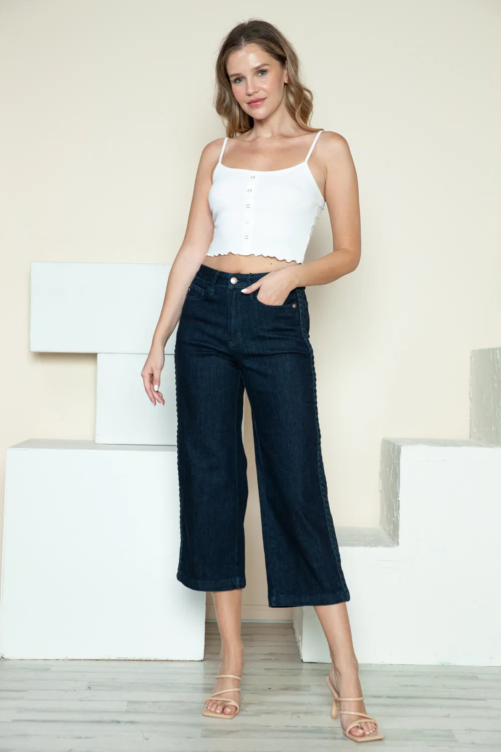 Dark denim wide-leg crop jeans with braided side seam detail, mid-rise fit