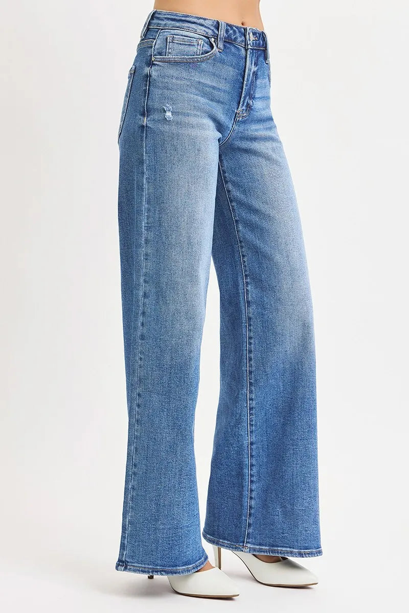 Side view high-rise wide-leg jeans, medium wash blue with button front and whisker lines.