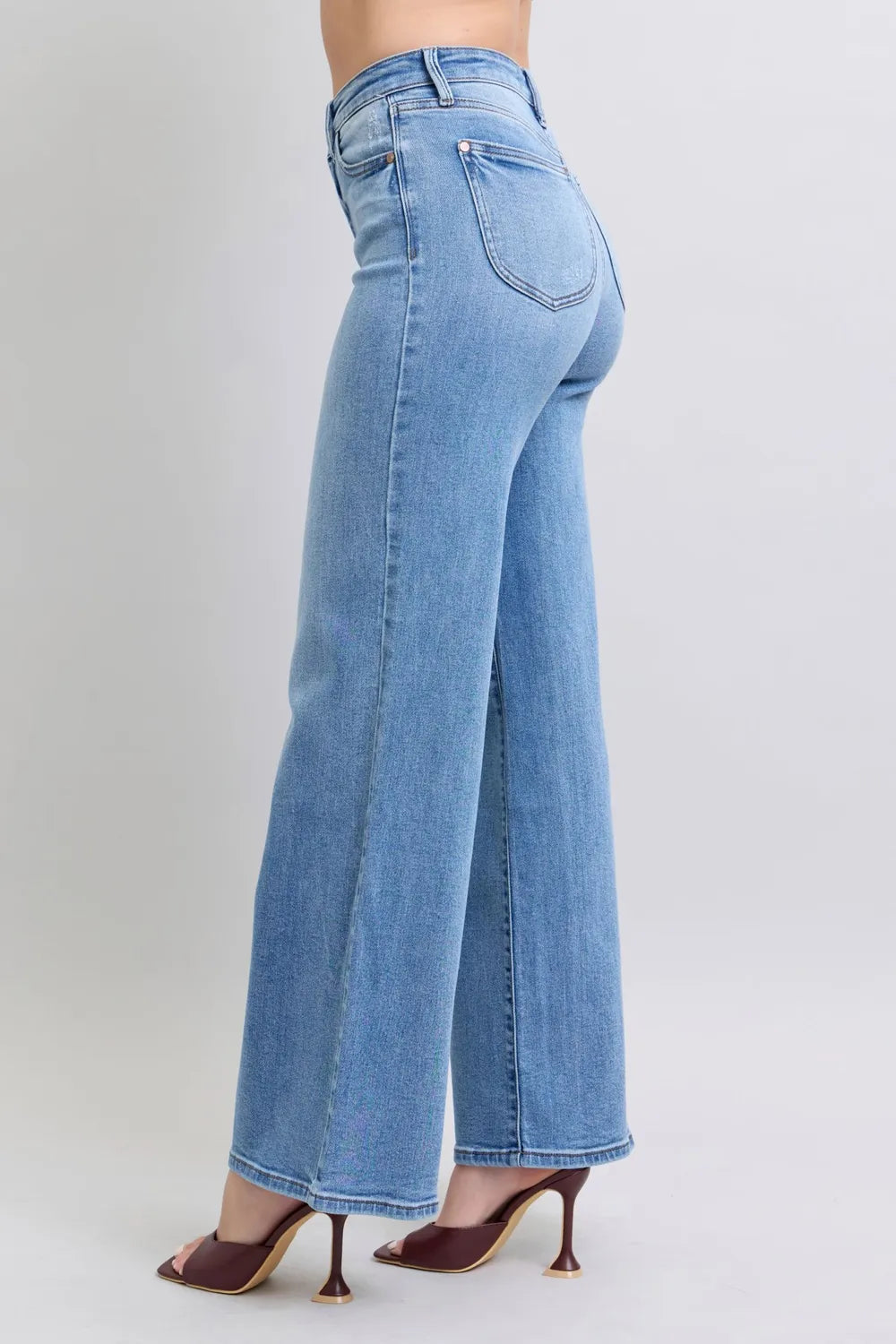 Medium-wash denim jeans, back view showing wide straight legs and rear yoke