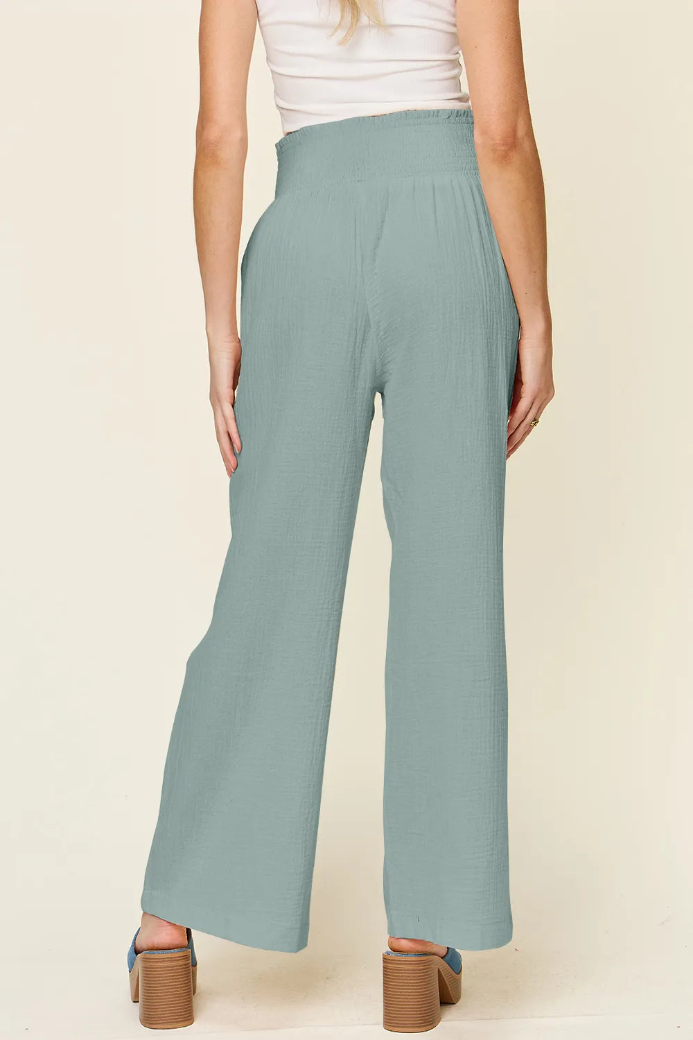 Teal wide-leg pants, smocked waist and relaxed straight legs, back view
