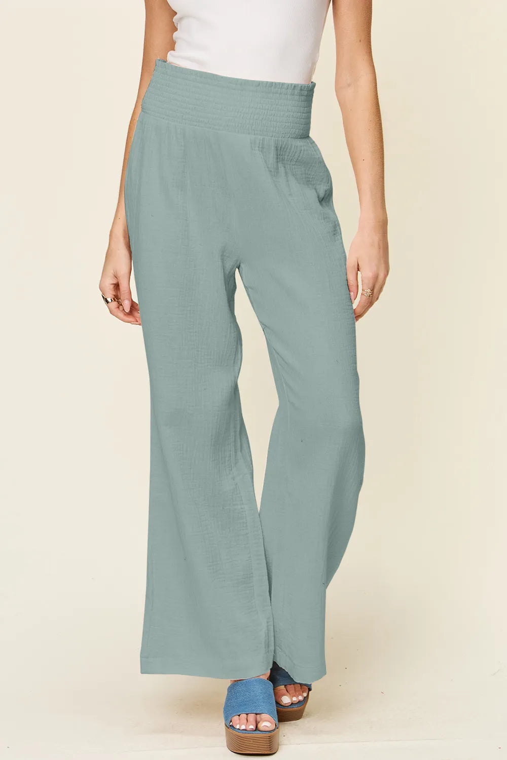 Teal smocked-waist wide-leg pants, front view, textured woven finish