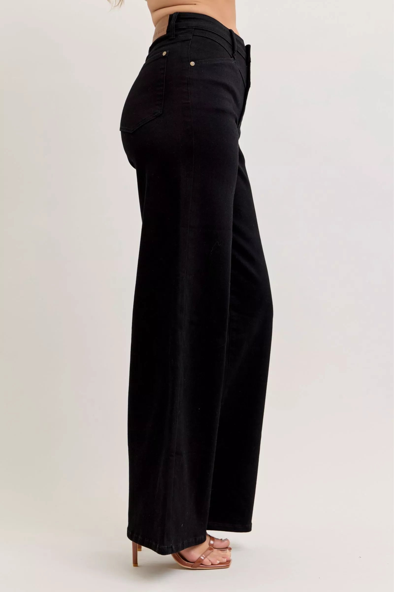 Side view of high-waisted wide-leg jeans in black, five-pocket styling