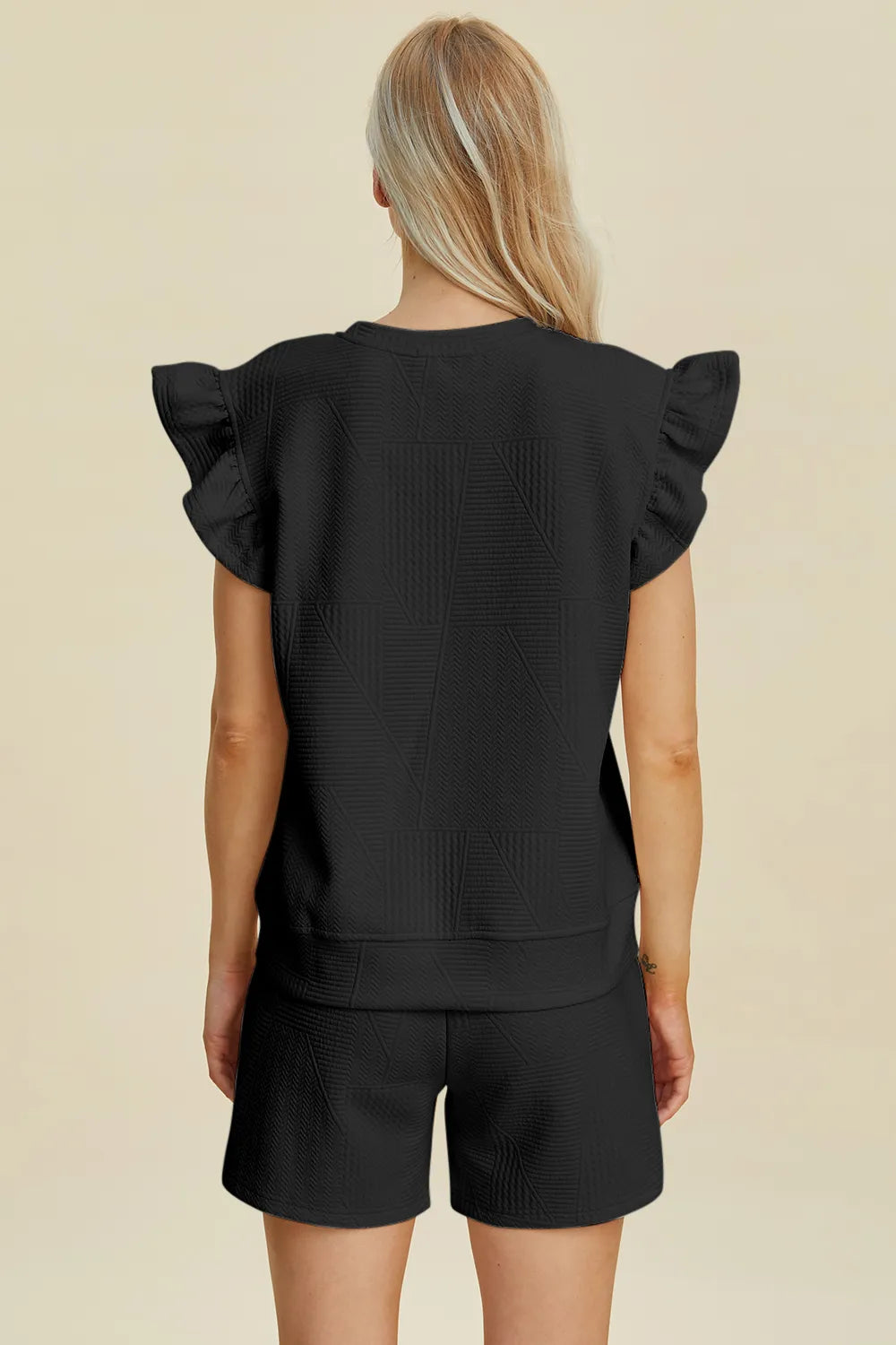 Back view of black textured ruffle sleeve top with matching shorts set