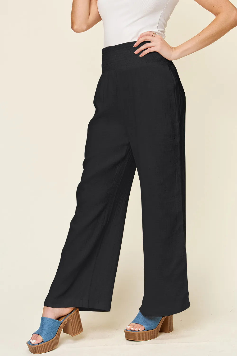 Black wide-leg pants, smocked waist, smooth textured weave