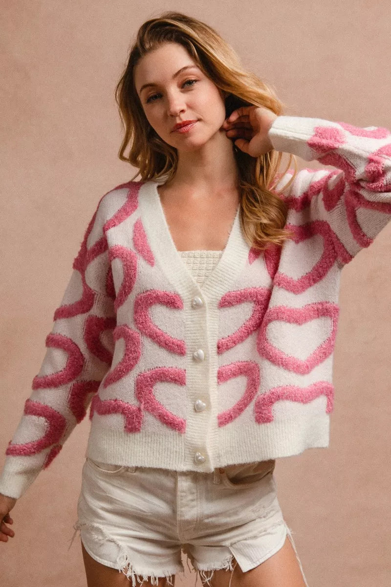 Cardigan blanco con botones, estampado rosa tipo corazón y escote en V