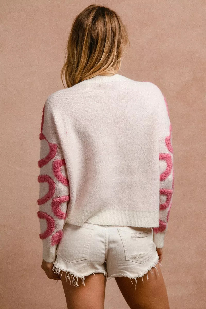 Parte trasera del cardigan blanco con mangas rosa y tejido de punto con botones