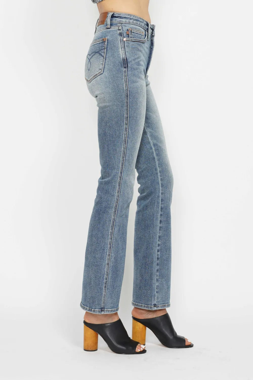 Light blue bootcut jeans, back close-up; flared hem and embroidered back pockets