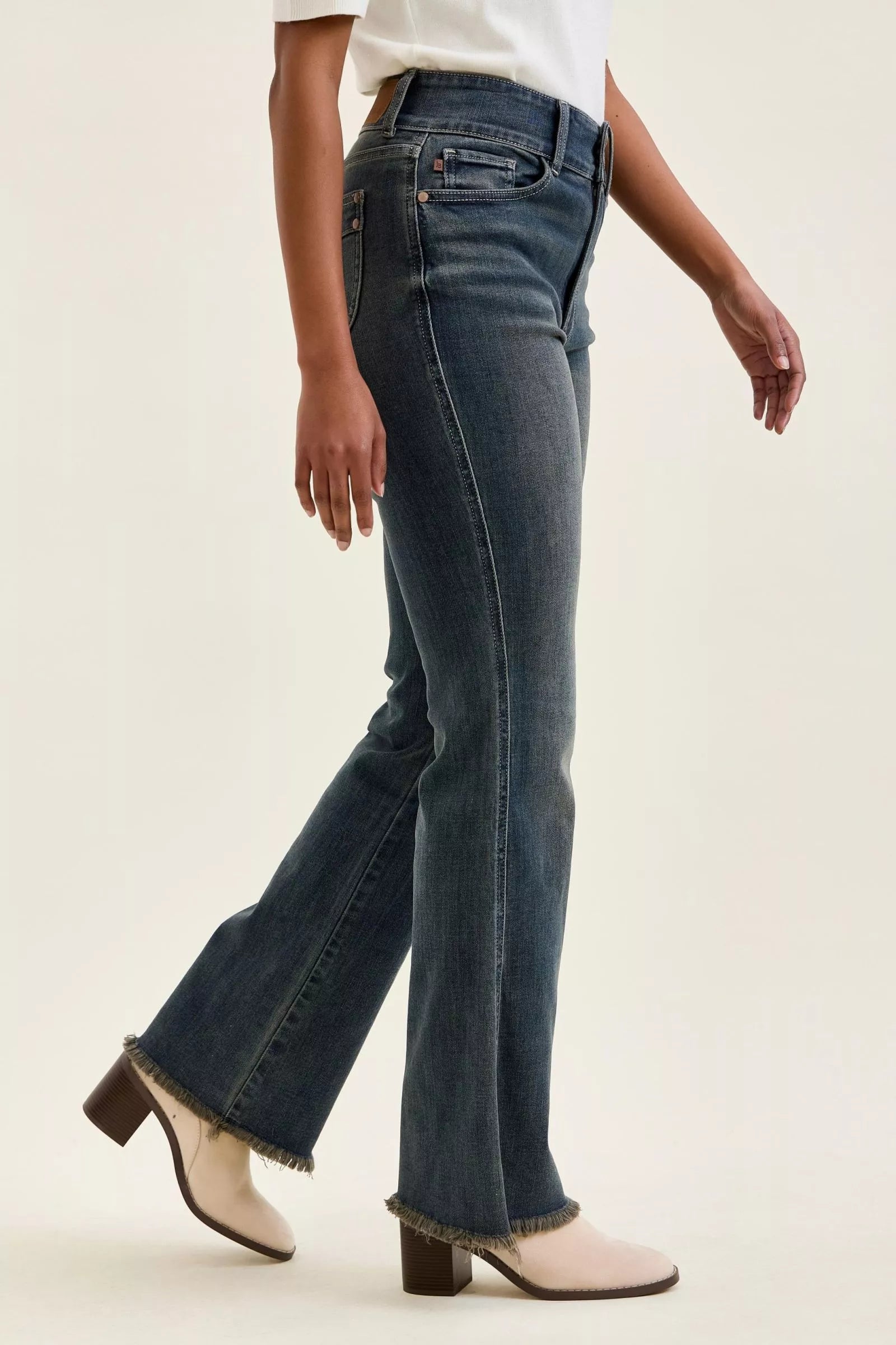 High-waist dark denim flared jeans with frayed hem and back yoke seam detail.