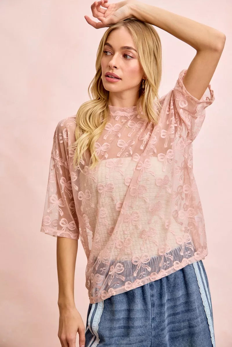 Dusty rose sheer mesh top with bow pattern, boxy fit and short sleeves