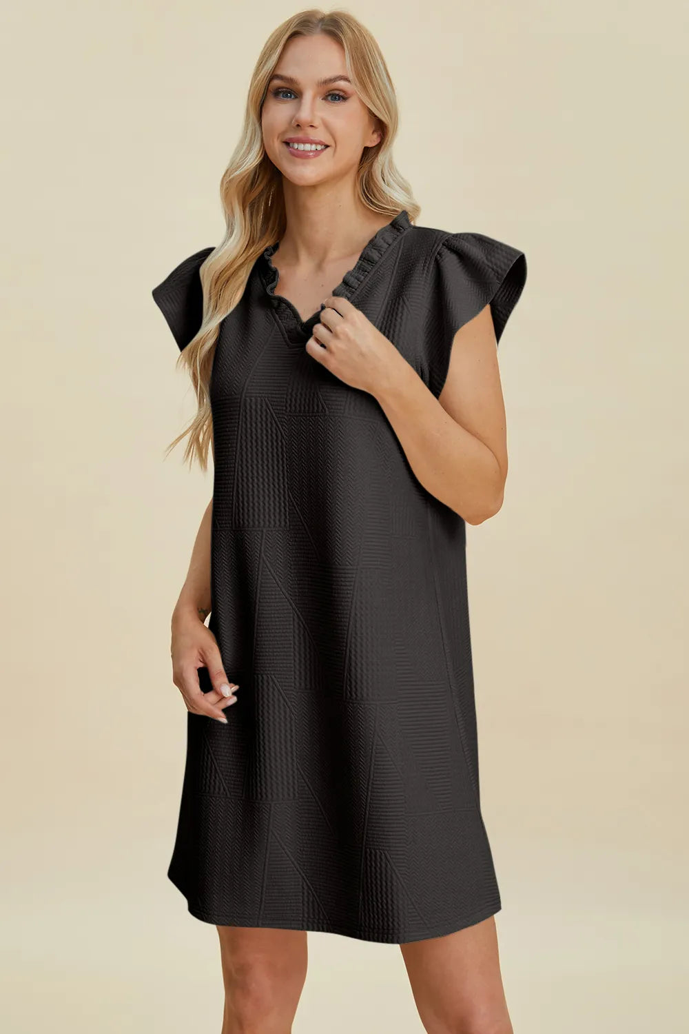 Ruffled V-neck cap sleeve dress in black, three-quarter front view with textured fabric.