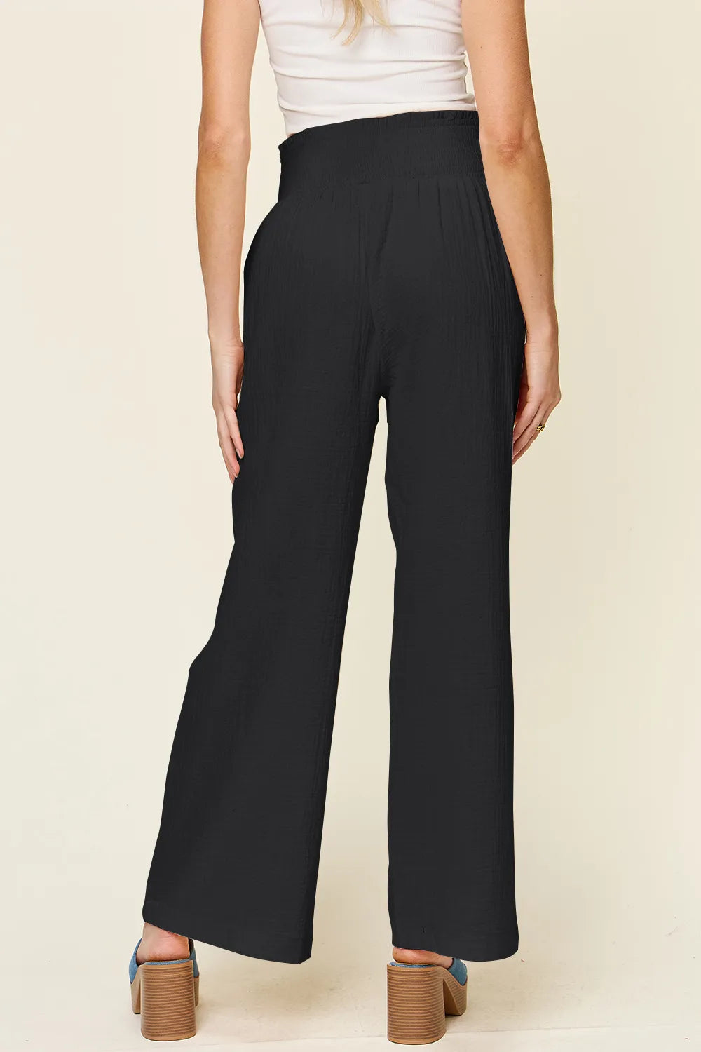 Black textured wide-leg pants with smocked waistband, back view
