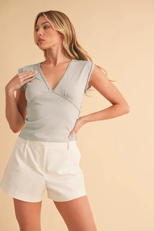 Light blue-gray V-neck cap sleeve cropped top, fitted with crossover neckline