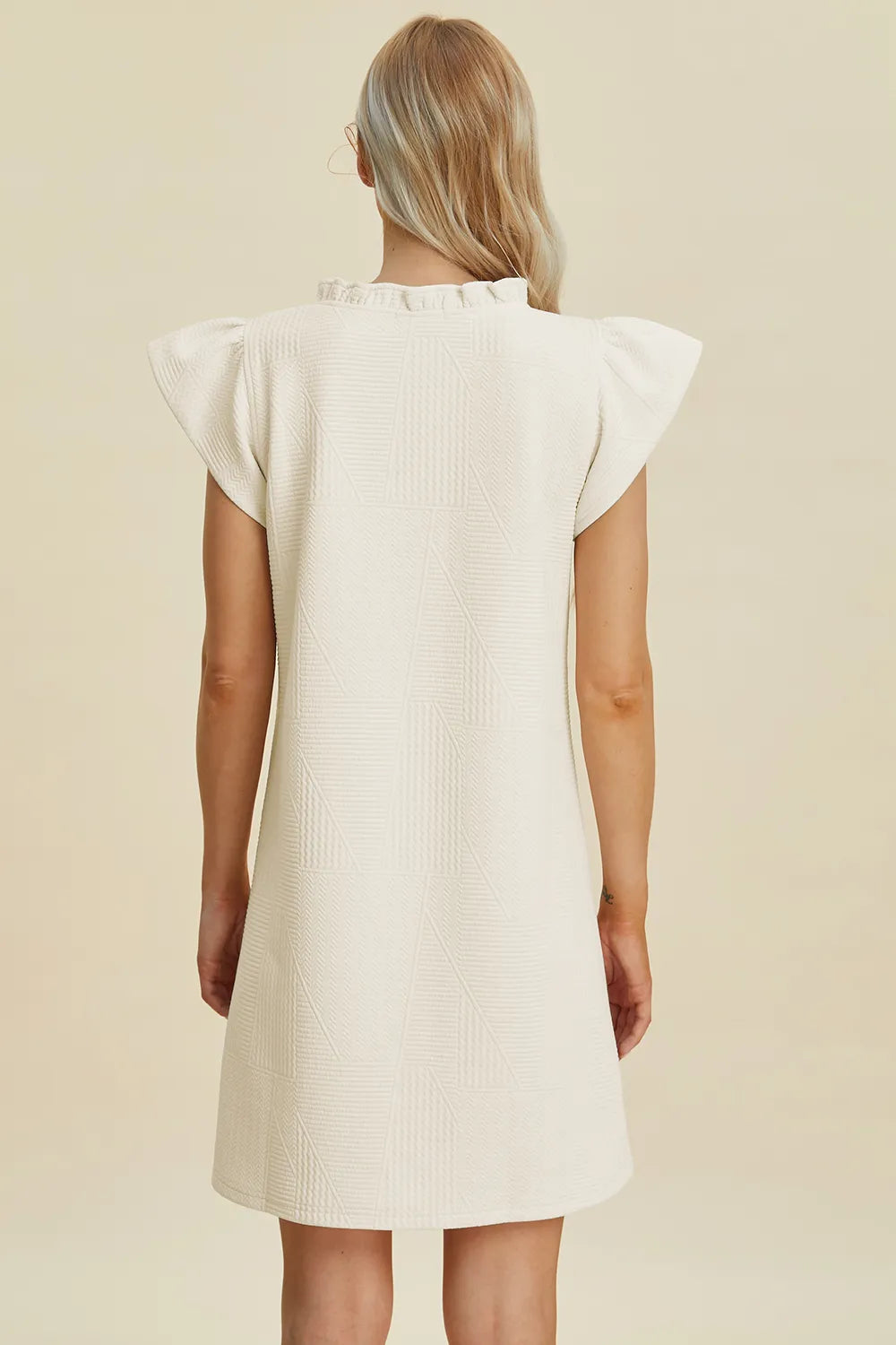 Cream ruffled V-neck cap sleeve dress, back view with flutter shoulders