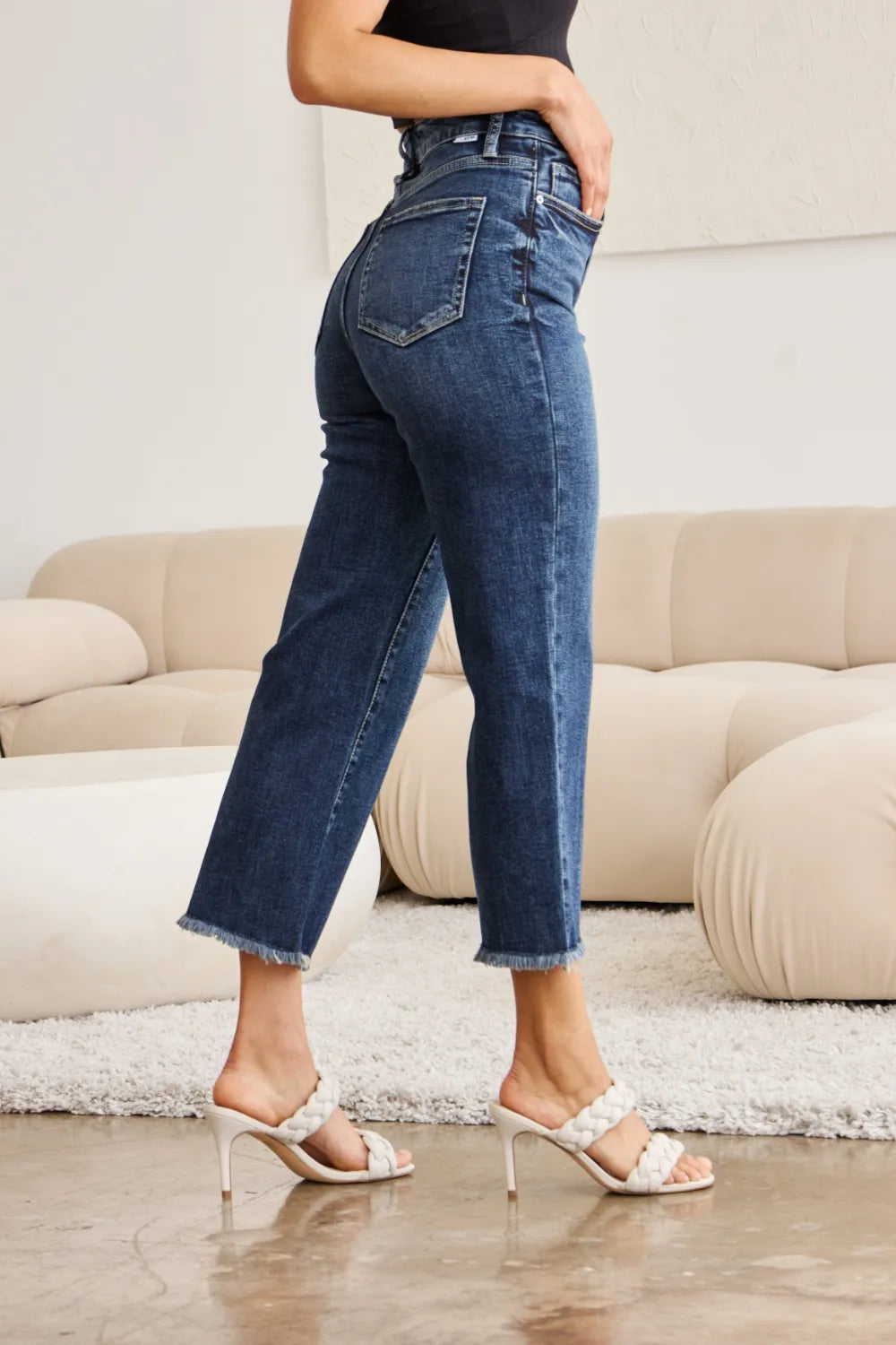 Dark-wash jeans with high waist, raw hem cuffs, and slight flare