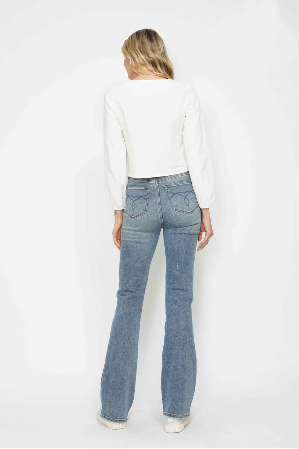 Light blue bootcut jeans from back with embroidered back pockets and belt loops