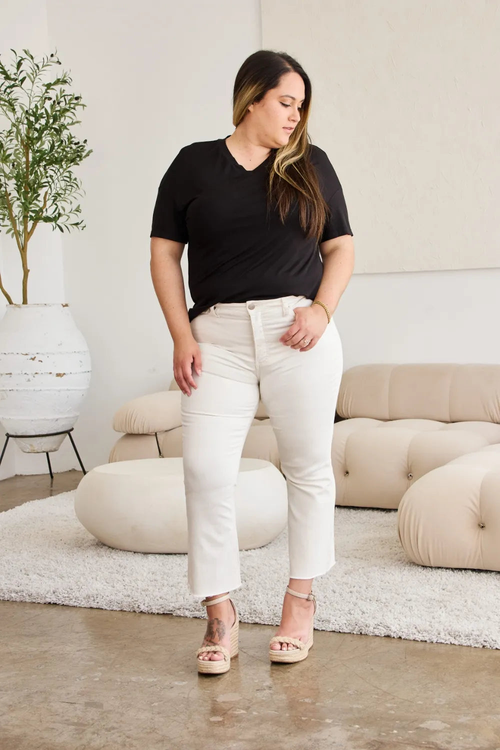 Off-white high-waist jeans with button closure and raw hem, full-length look