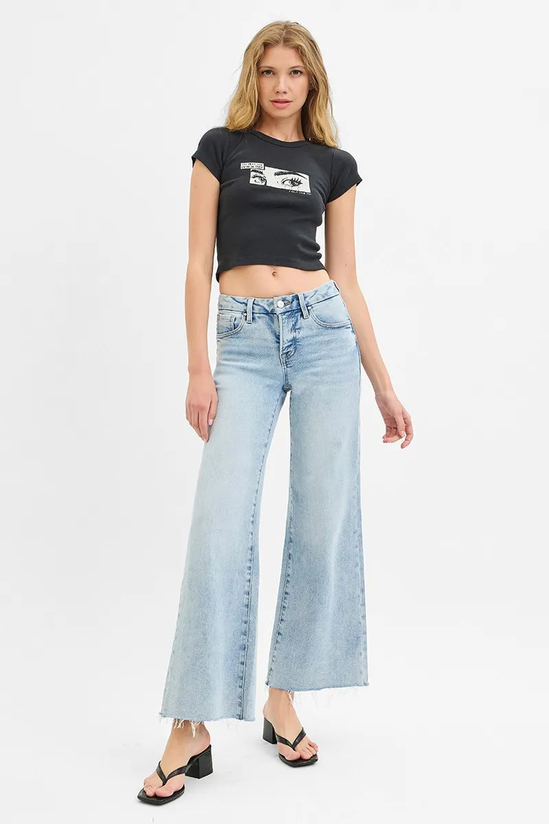 Light-wash wide-leg jeans on model, low rise, raw-cut frayed hem