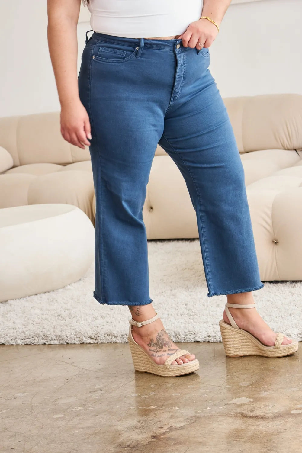 Blue denim jeans, high waist with raw frayed cuffs and classic 5-pocket style
