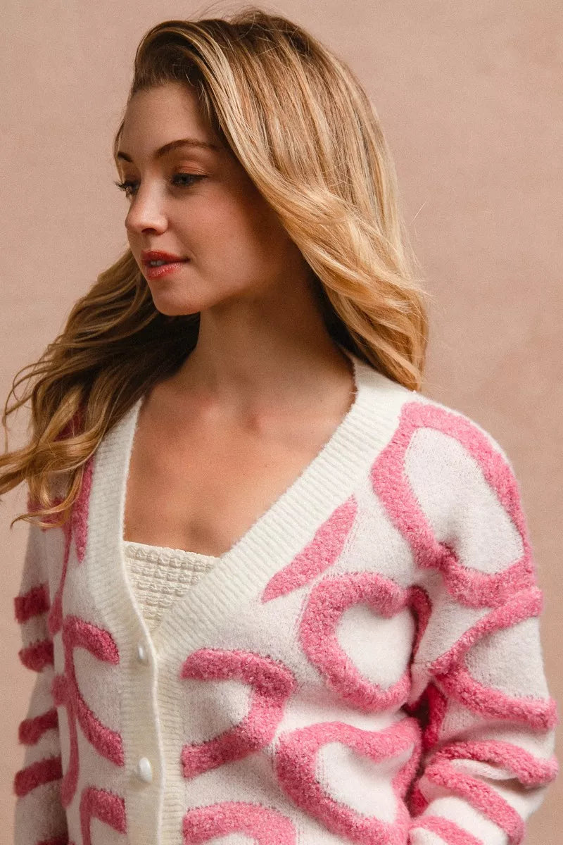 Cardigan V con botones, tejido blanco y rosa con corazones texturizados