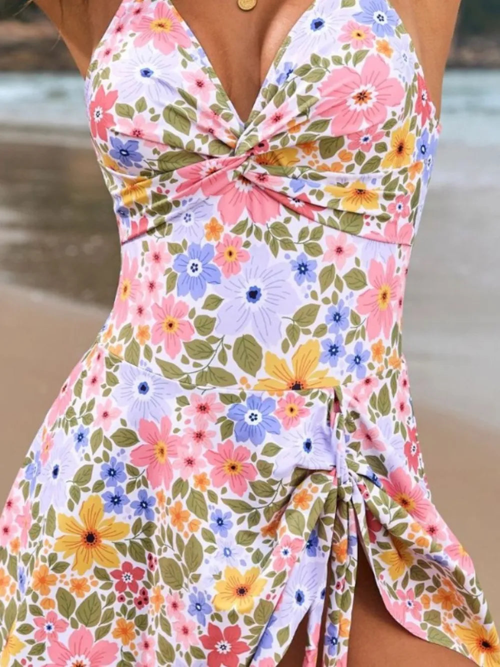 Floral one-piece swimsuit close-up: twisted front crisscross neckline with double spaghetti straps.