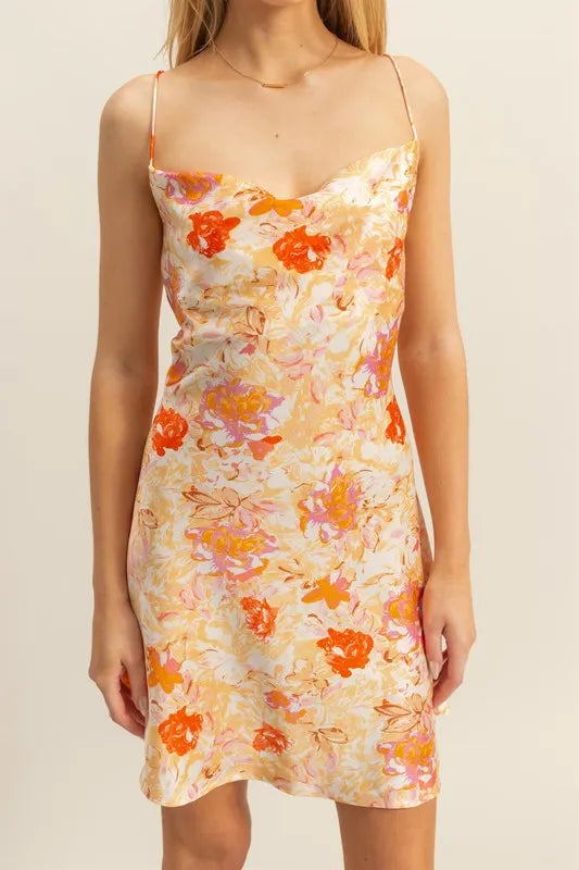 Close-up: floral satin mini dress with cowl neckline, orange flower print on cream