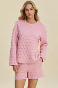 Pink quilted long-sleeve top and matching shorts set, round neck, geometric texture.