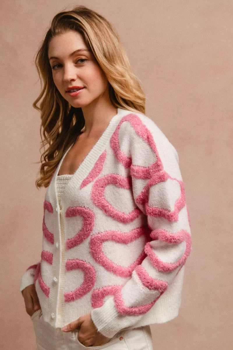 Cardigan blanco con botones y corazón rosa en el frente, cuello en V
