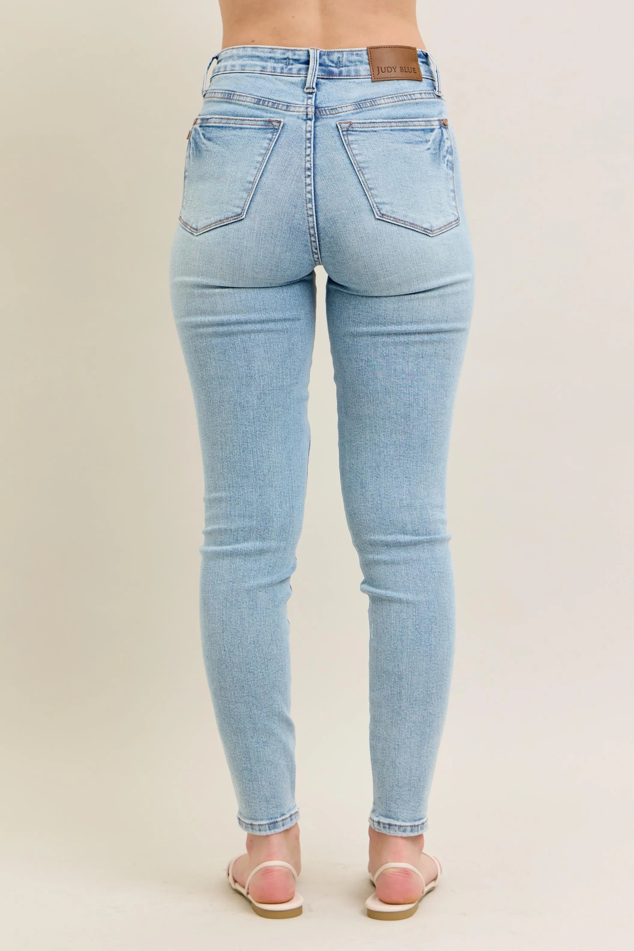 Light wash skinny jeans, rear view, slim tapered fit with belt loops