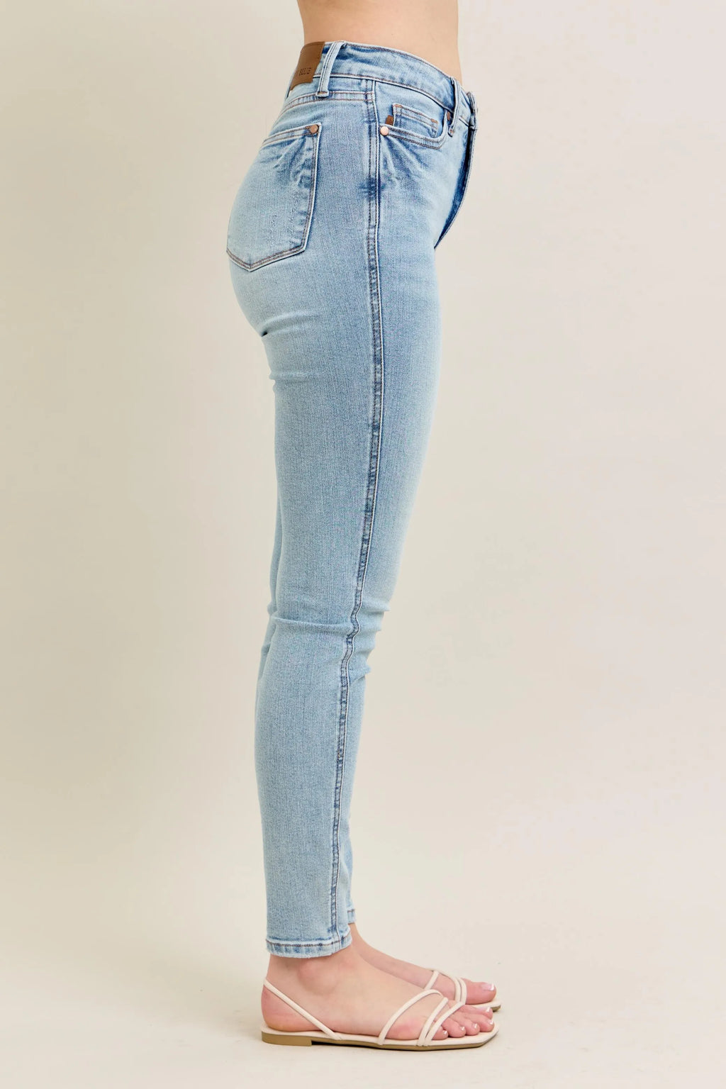 Light wash skinny jeans, rear view detail, tapered leg and back yoke seams