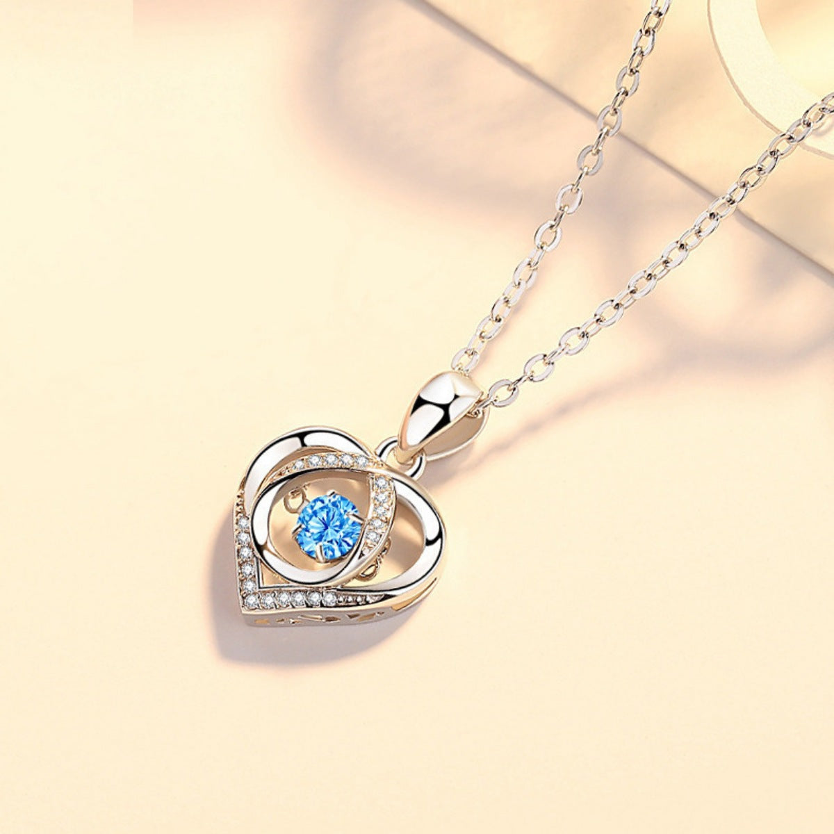 Herz-Anhänger Halskette mit blauem Stein, geschwungenem Rahmen und Glitzersteinen