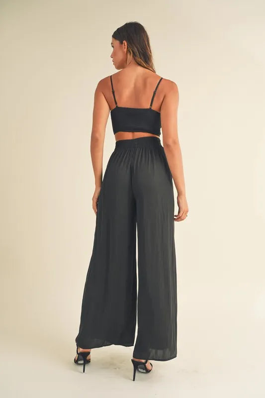 Vista trasera del conjunto negro: bralette corto y pantalón palazzo ancho fruncido