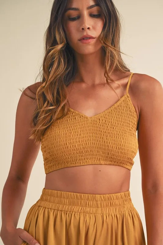 Gold mustard smocked bralette crop top close-up with thin spaghetti straps