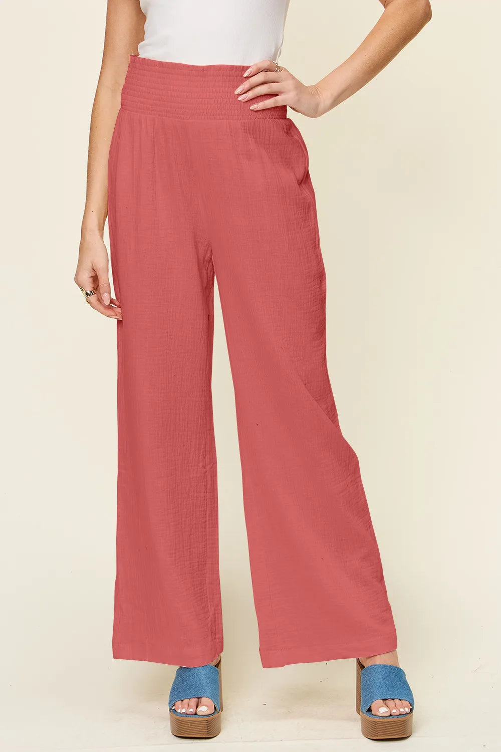 Hot pink wide-leg pants with smocked waist and textured fabric