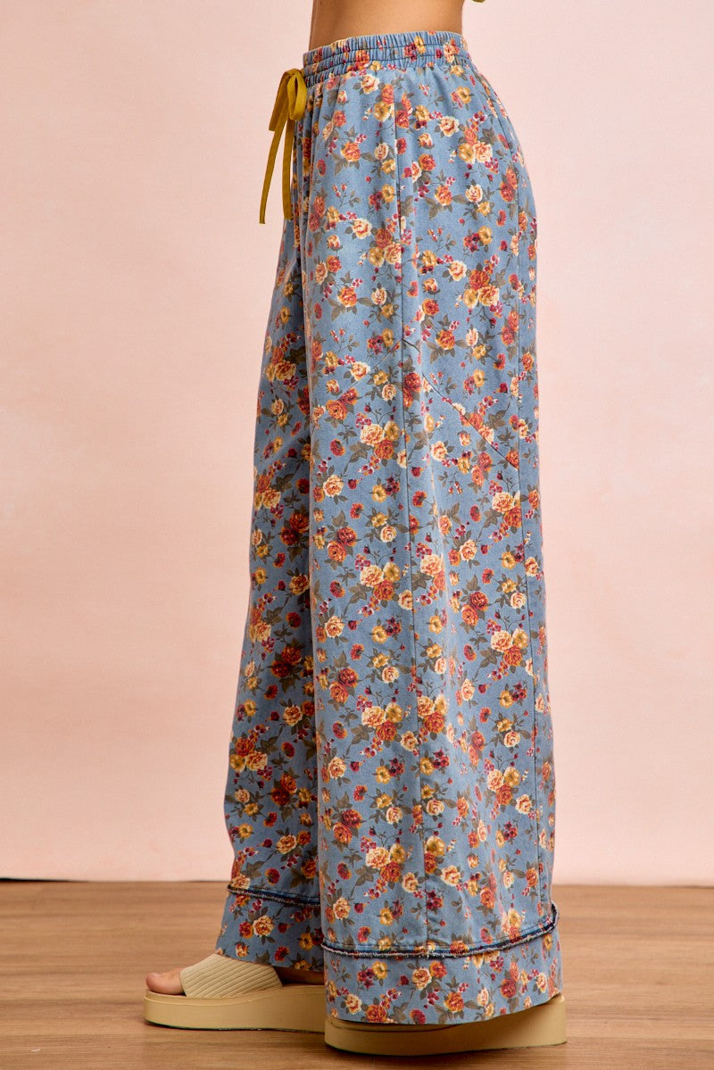 Denim-blue floral wide-leg pants from back; elastic waistband and drawstring